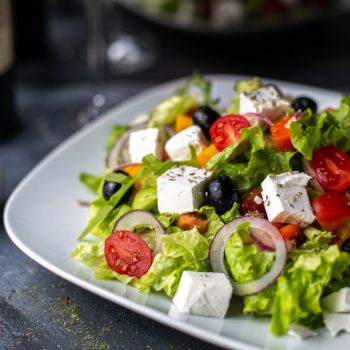 front-view-greece-salad-sliced-vegetable-salad-with-tomatoes-cucumbers-white-cheese-olives-inside-white-plate-vitamine-vegetables